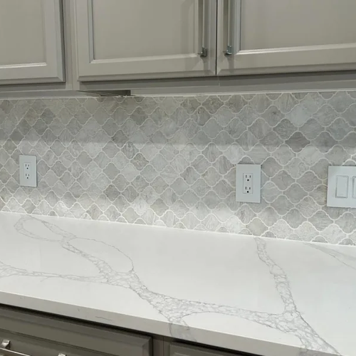 White marble countertops and grey tile backsplash